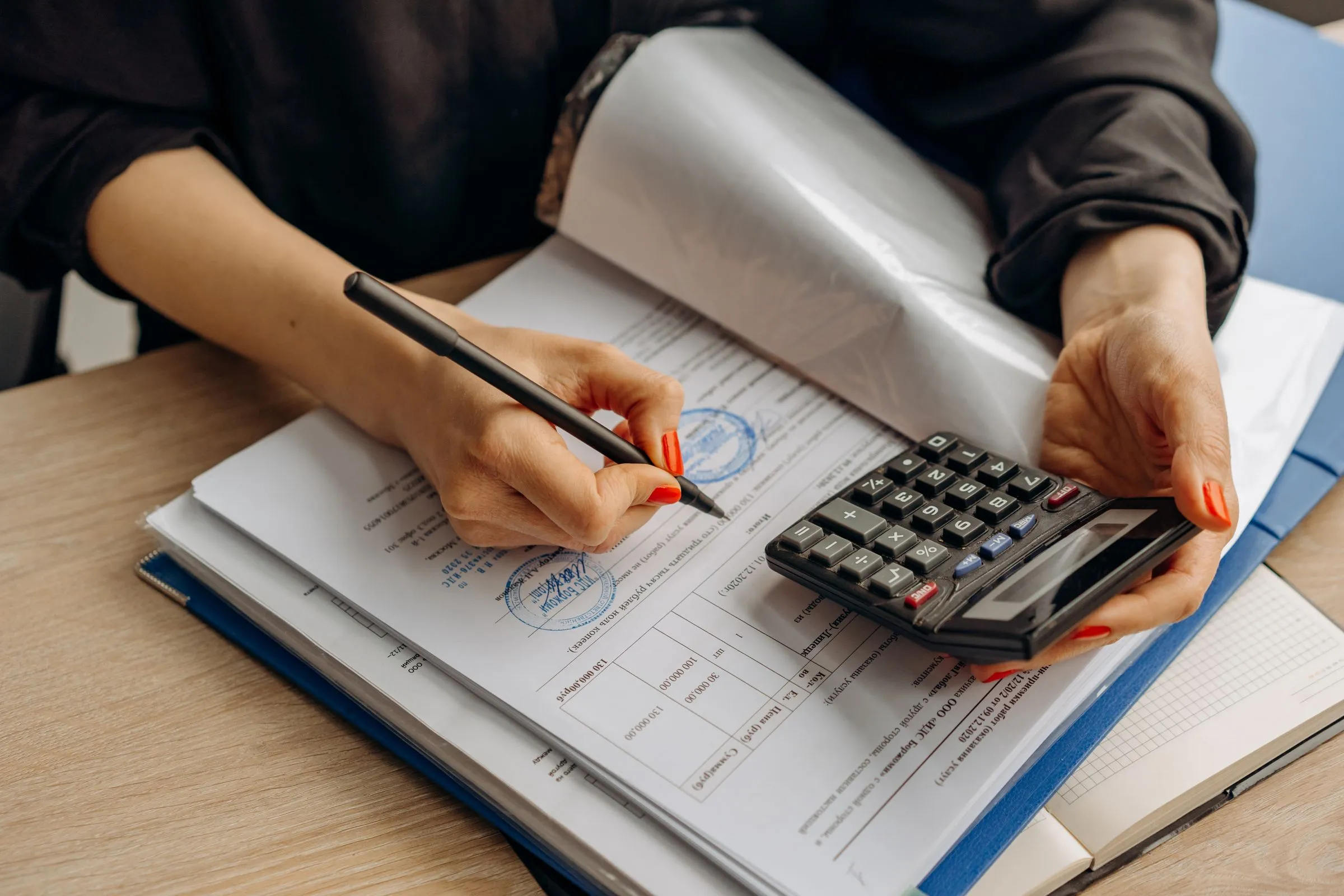 An accountant checking working papers with a calculator