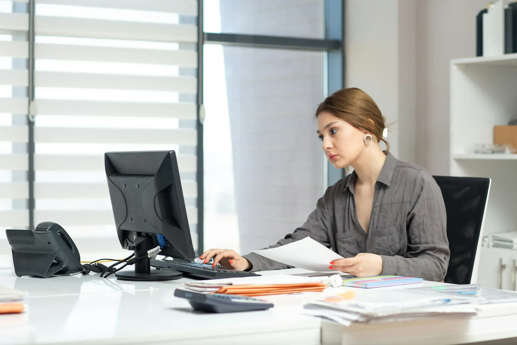 A bookkeeper checking client paperwork at her desk